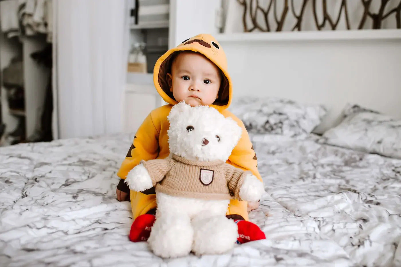 a fomo baby holding a bear toy